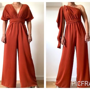 Könnte beinhalten: Zwei Ansichten eines rostfarbenen Jumpsuits mit weitem Bein. Die erste Ansicht zeigt den Jumpsuit mit V-Ausschnitt und kurzen Ärmeln. Die zweite Ansicht zeigt den Jumpsuit mit einem One-Shoulder-Design und einem drapierten Ärmel.