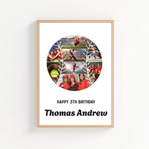 May include: A framed print featuring a collage of softball action shots within a circular design. The print includes the text "HAPPY 5TH BIRTHDAY" and the name "Thomas Andrew" in a bold, black font. The frame is a light wood color.