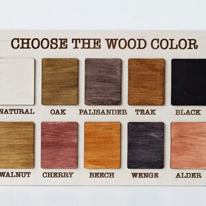 May include: A wooden color chart with the text "CHOOSE THE WOOD COLOR" at the top. The chart displays ten wood color samples labeled "NATURAL", "OAK", "PALISANDER", "TEAK", "BLACK", "WALNUT", "CHERRY", "BEECH", "WENGE", and "ALDER".