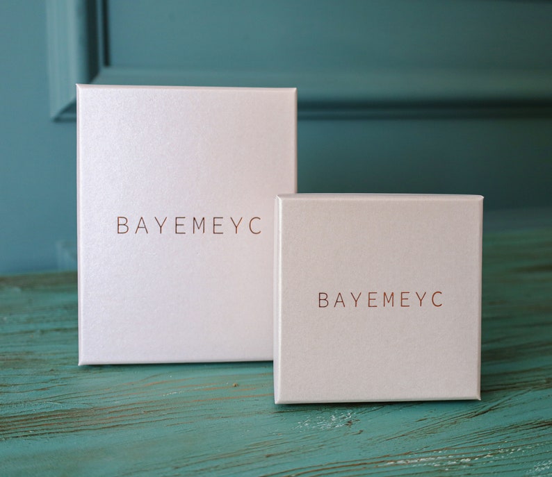 May include: Two white boxes with the text "BAYEMEYC" printed in copper on the front.