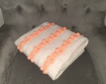 White a peach bobble stitch crochet baby blanket