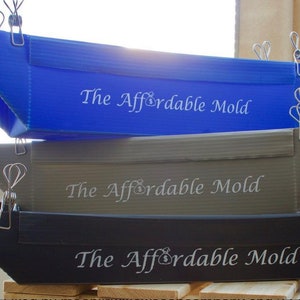 May include: Three plastic molds stacked on top of each other. The top mold is blue, the middle mold is gray, and the bottom mold is black. Each mold has the words "The Affordable Mold" printed on it.