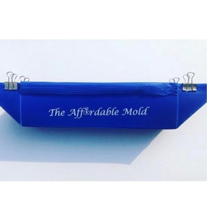 May include: A blue plastic mold with the text "The Affordable Mold" printed on it. The mold is held together with binder clips.