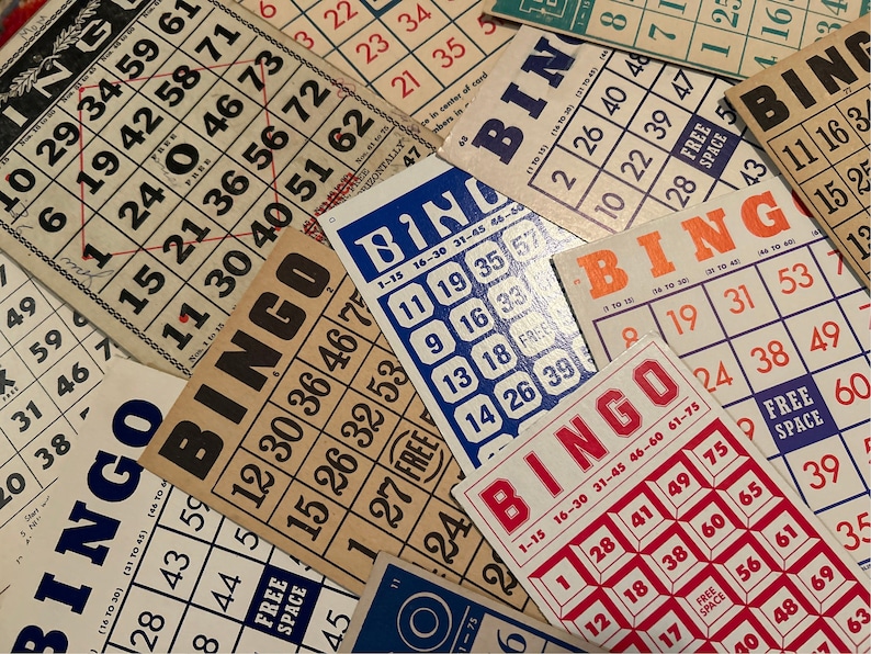 Pu&ograve; includere: Primo piano di diverse carte da bingo con sfondi e numeri di colori diversi. Le carte sono disposte in ordine casuale, alcune si sovrappongono. I numeri sulle carte sono in una variet&agrave; di caratteri e dimensioni.