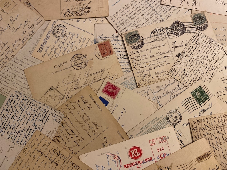 May include: A close-up image of a pile of vintage postcards and envelopes with handwritten messages and stamps. The postcards are in various shades of brown and cream, with some showing signs of wear and tear. The stamps are colorful and feature different designs.