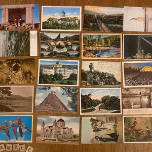 May include: A collection of vintage postcards featuring various scenes, including a building with a dome, a river, a bridge, a cityscape, and a lighthouse. The postcards are in various colors and have a worn, vintage look.