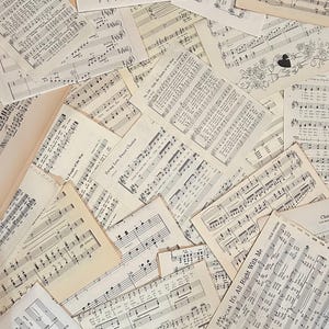 Puede incluir: Una colección de páginas de partituras antiguas superpuestas con notación musical negra, letras y títulos como Swing Low, Sweet Chariot y Can-Can It's All Right With Me impresos en papel envejecido de color blanco roto con varias texturas.