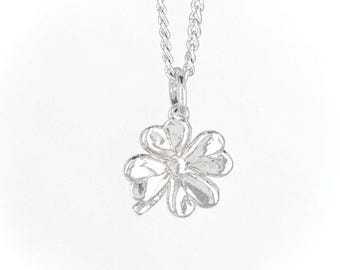 May include: A silver necklace with a four-leaf clover pendant.