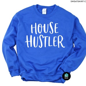 Peut inclure: Sweat-shirt bleu roi avec le texte blanc "HOUSE HUSTLER". Le sweat-shirt &agrave; col rond est de couleur unie et poss&egrave;de un col, des poignets et un ourlet c&ocirc;tel&eacute;s. Le sweat-shirt est de style d&eacute;contract&eacute;.