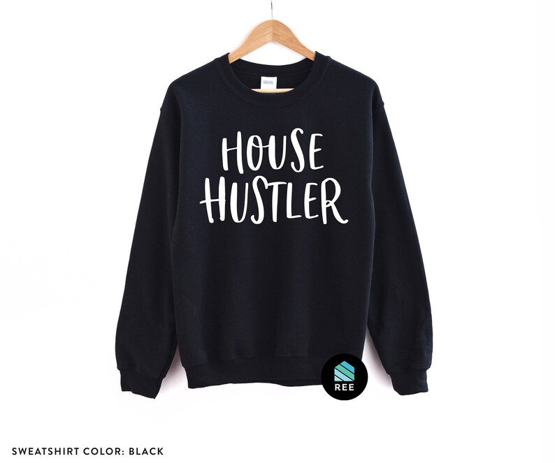 Peut inclure: Sweat-shirt noir avec le texte blanc "HOUSE HUSTLER". Le haut &agrave; manches longues est suspendu &agrave; un cintre en bois. Le sweat-shirt est de couleur noire unie.