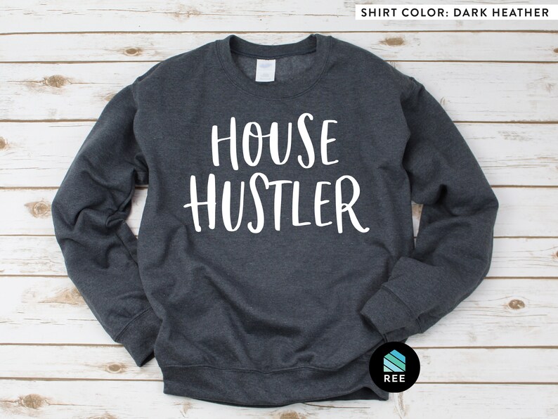 Peut inclure: Sweat-shirt gris fonc&eacute; avec le texte blanc "HOUSE HUSTLER". Ce sweat-shirt &agrave; col rond a des manches longues. La couleur du t-shirt est gris fonc&eacute;.