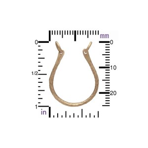 May include: A single, open-hoop earring in a light, textured metal. The earring is approximately 1 inch in diameter. The design is a simple, curved shape with a small loop at the top for attachment.