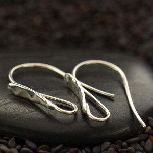 May include: A pair of silver hammered wire earrings with a hook fastening.