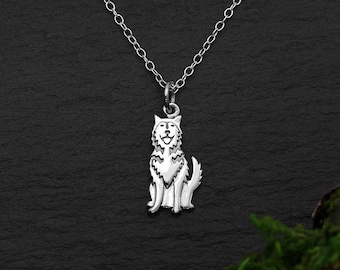 May include: A silver necklace with a charm of a sitting wolf. The wolf is stylized and has a simple design.