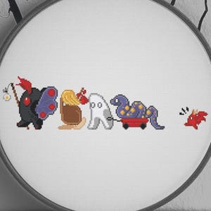 May include: A cross-stitch embroidery hoop featuring a line of whimsical, colorful creatures. The creatures include a black monster, a brown creature with a butterfly, a ghost, a purple creature in a wagon, and a red creature. The text "ByMegC" is at the bottom.