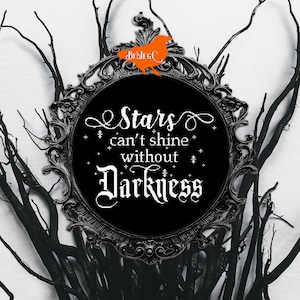 May include: Black and white cross-stitch embroidery in a black ornate frame. The embroidery reads "Stars can't shine without Darkness".