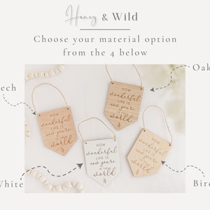 May include: Four wooden signs with the text "How wonderful life is now you're in the world" in different wood finishes: beech, white, oak, and birch.