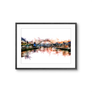 May include: A framed watercolor print depicting a city skyline with a prominent arched bridge spanning a river. The artwork features warm orange and cool blue tones, with reflections of the buildings and bridge visible on the water surface.