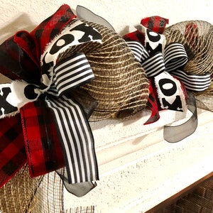 May include: A black, white, and red Christmas swag with burlap and mesh. The swag has a "XO" design on it.