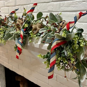 May include: A festive garland with red, white, and blue ribbon accents, featuring greenery and burlap accents. The garland is perfect for a patriotic celebration.