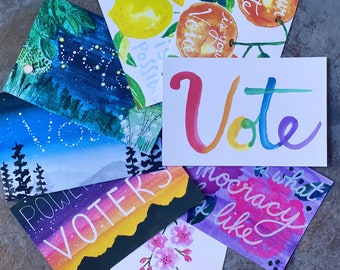 May include: A collection of rectangular postcards featuring watercolor illustrations and hand-lettered text. Designs include a rainbow-colored Vote, a night sky with constellations, a sunset with the word VOTERS, and floral motifs with text.