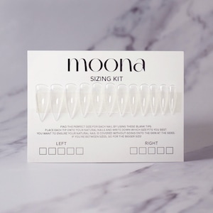 May include: A white plastic nail sizing kit with clear plastic nail tips. The kit includes a card with the words "moona sizing kit" and instructions for finding the correct size for each nail. The card has two sections labelled "left" and "right" with boxes for writing down the size of each nail.