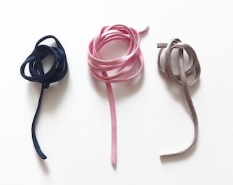 Puede incluir: Tres carretes de cordón, uno azul marino, uno rosa y uno marrón claro.