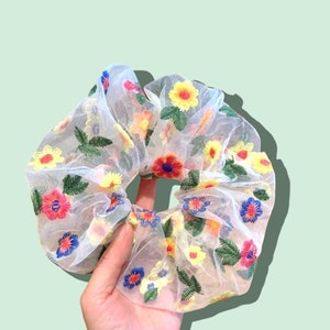 Puede incluir: Scrunchie de pelo de malla blanca con flores bordadas de colores.