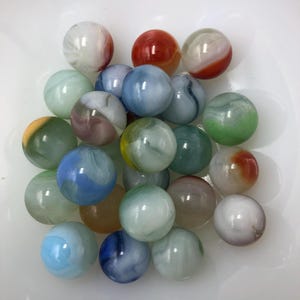 May include: A collection of colorful glass marbles with swirls and patterns. The marbles are various shades of blue, green, red, white, and yellow.
