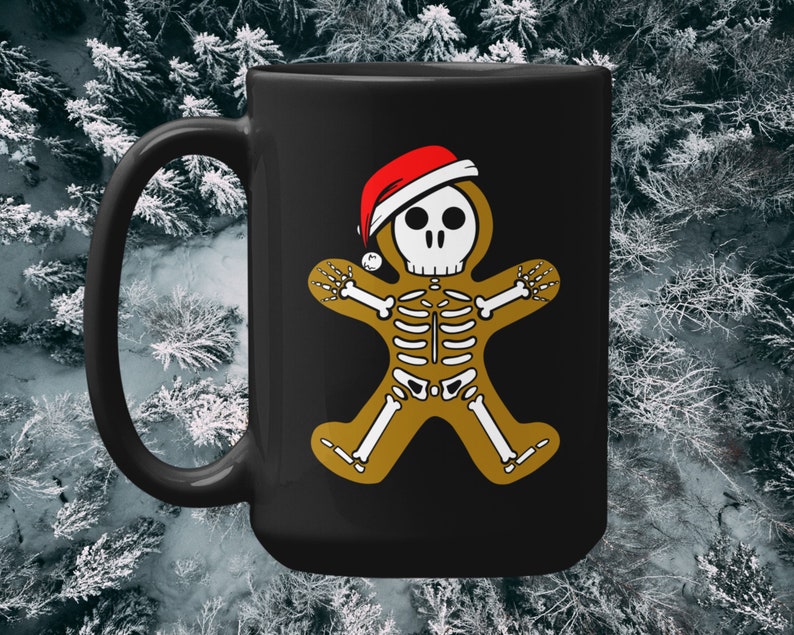 Pode incluir: Caneca de caf&eacute; preta com um homem de gengibre esqueleto branco usando um chap&eacute;u de Papai Noel vermelho e branco. O homem de gengibre &eacute; contornado em ouro.