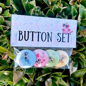 May include: A button set in a clear plastic package, with a decorative box. The box reads "BUTTON SET" and features a pink dragon illustration. The set includes four colorful buttons, each with a different cartoon dragon design.