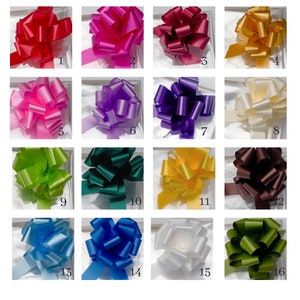May include: A collection of 16 different coloured gift bows. The bows are arranged in a grid pattern, with each bow having a different colour. The colours include red, pink, purple, white, green, blue, yellow, and brown.