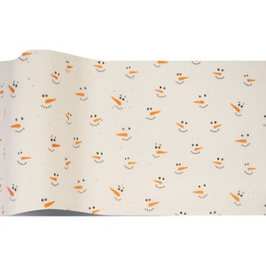 May include: White wrapping paper with a repeating pattern of orange snowman faces. The paper has a subtle glitter finish.