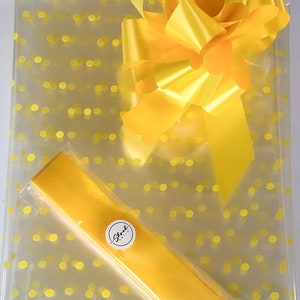 May include: Yellow cellophane gift wrap with yellow polka dots and a yellow satin ribbon bow. The wrap has a small white sticker with the text "Shroud Boutique".