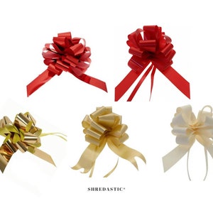 May include: Five gift bows in different colours. Two red bows, one gold bow, one yellow bow, and one white bow. The bows are all made of shiny, crinkled ribbon.