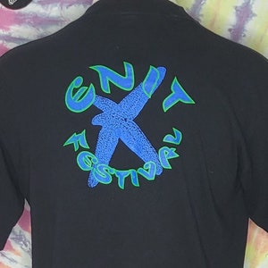 May include: Black t-shirt with a green and blue graphic of a starfish and the text "Enit Festival".