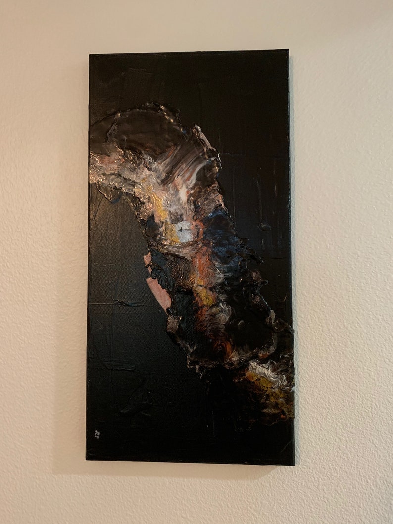 May include: Abstract painting on canvas with a black background and a large, textured, brown, white, and gold shape in the center.