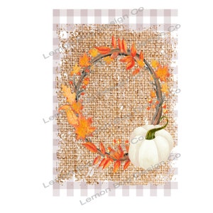 Op de afbeelding: Een aquarelontwerp met een witte pompoen met een groene steel, omringd door een krans van herfstbladeren in oranje en rode tinten. De krans staat tegen een achtergrond van jute textuur.