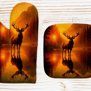 Könnte beinhalten: Ofenhandschuh- und Topflappen-Set mit einem majestätischen Hirsch in einer ruhigen Waldszene. Das Kunstwerk zeigt den Hirsch im Wasser, mit einem Sonnenuntergang im Hintergrund. Die Farbpalette umfasst Orange-, Braun- und Gelbtöne, was eine warme Ästhetik erzeugt.
