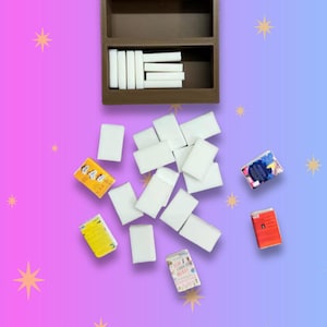 May include: A brown three-tiered rectangular shelf organiser containing several white rectangular blocks. Below the shelf, a collection of white rectangular blocks and four small rectangular books with colourful covers are scattered.