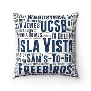 May include: White square throw pillow with a navy blue text design. The pillow features the words "ISLA VISTA" prominently, surrounded by a collage of other words and phrases, including restaurant names and local landmarks.