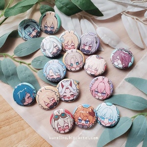 Könnte beinhalten: Eine Sammlung runder Charakter-Ansteckbuttons. Jeder Button zeigt einen anderen Anime-Charakter mit unterschiedlichen Haar- und Augenfarben. Die Buttons sind auf einer hellen Oberfläche mit grünen Blättern angeordnet.