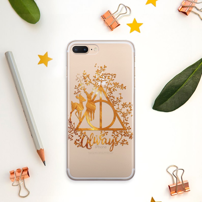 May include: A clear phone case with a gold design of the Deathly Hallows symbol, a stag, and the word "Always".
