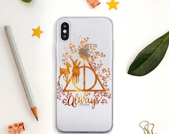 May include: A clear iPhone case with a gold design featuring the Deathly Hallows symbol, two golden deer, and the word "Always" with the word "iPhone" underneath.