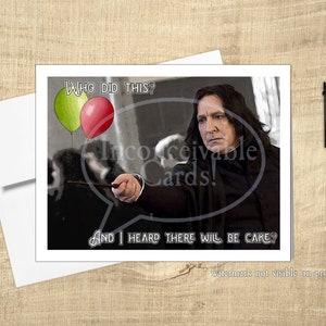 May include: Greeting card featuring a portrait of a man holding a wand, with text that reads "Who did this?" and "And I heard there will be cake?" Two balloons are also visible. A blue pen rests on a wooden surface.