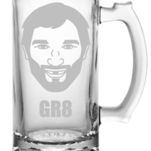 May include: A clear glass beer stein with a personalized design. The design features a cartoon face with a beard and the text "GR8".