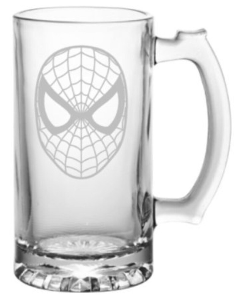 Puede incluir: Una jarra de cerveza de vidrio transparente con un dise&ntilde;o grabado en blanco de la m&aacute;scara de Spider-Man.