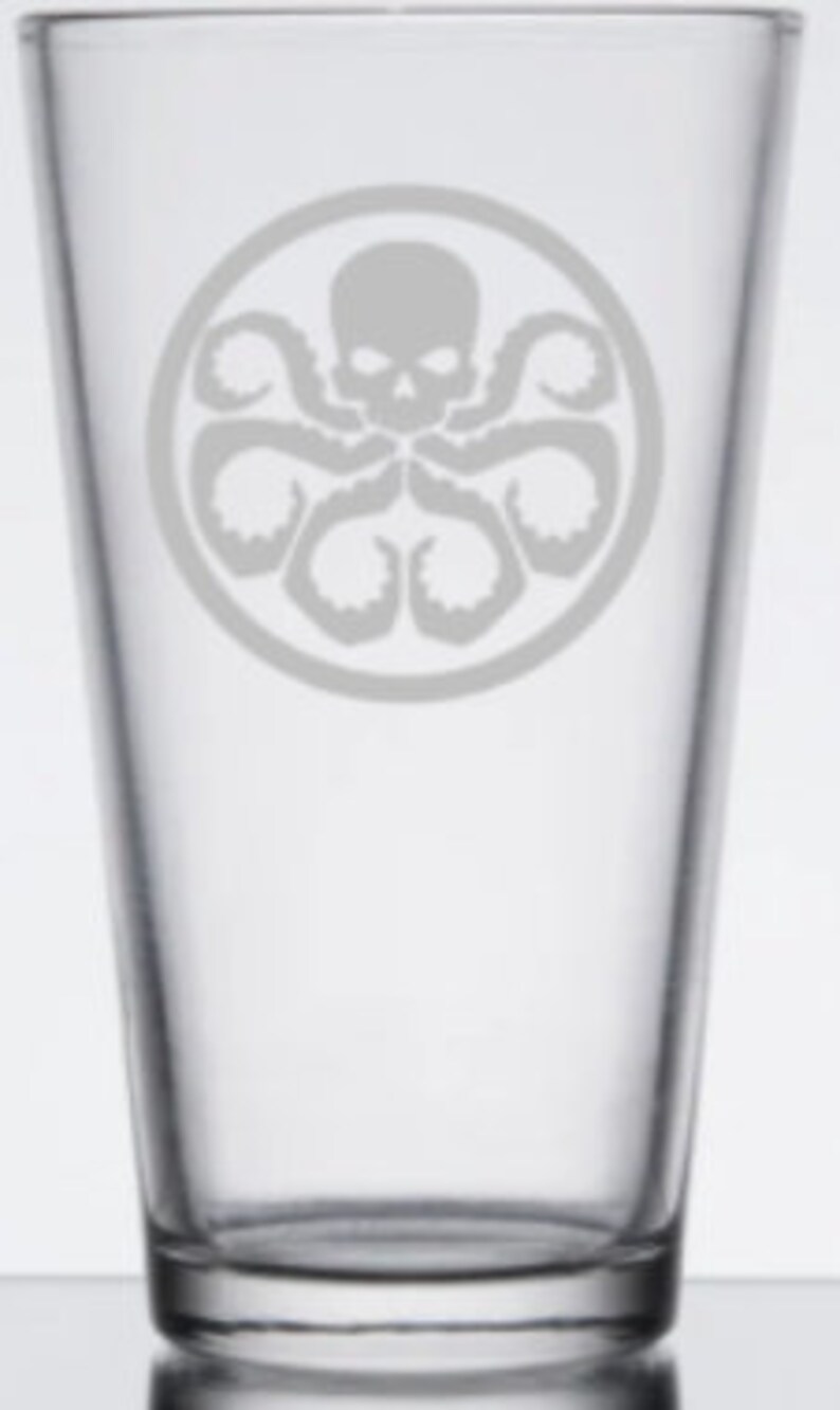 May include: A clear glass pint glass with a white etched design of the Hydra logo from the Marvel Cinematic Universe. The logo features a skull with tentacles.