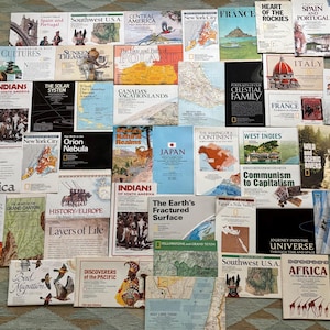 May include: A collection of numerous National Geographic maps and magazines featuring diverse titles such as Spain and Portugal, The Solar System, Japan, and Africa, arranged in a grid-like pattern with various illustrations and text.