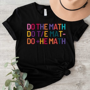 May include: Black t-shirt with the text "DO THE MATH" in rainbow colours. The text is written in a playful way, with different colours and fonts for each word.
